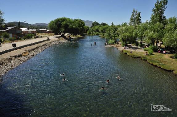 Pessoas nadam no delicioso rio de águas limpas e transparentes que corta a cidade de Junín de Los Andes, na Argentina